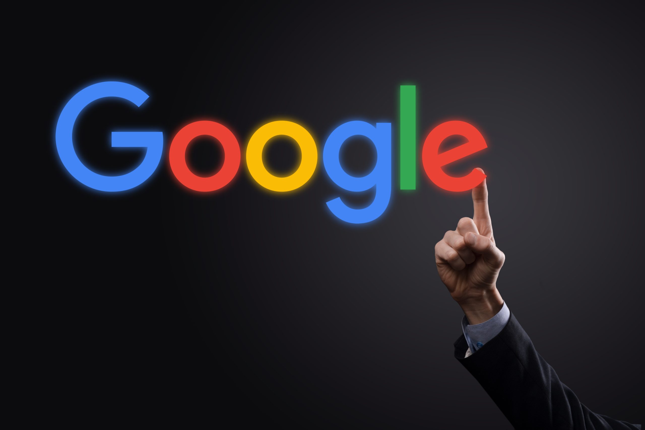 WINOGRADIW, UKRAINE - 30. DEZEMBER 2020. Geschäftsmann in einem Anzug auf einem dunklen Hintergrund hält ein Google-Logo Inschrift. Google ist die beliebteste Suchmaschine der Welt.