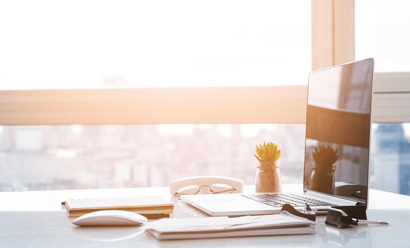 Helles und Sonnendurchschienenes Büro mit Macbook