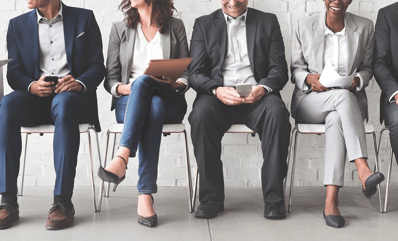Bewerber sitzen in einer Reihe und bereiten sich für ihr Gespräch vor
