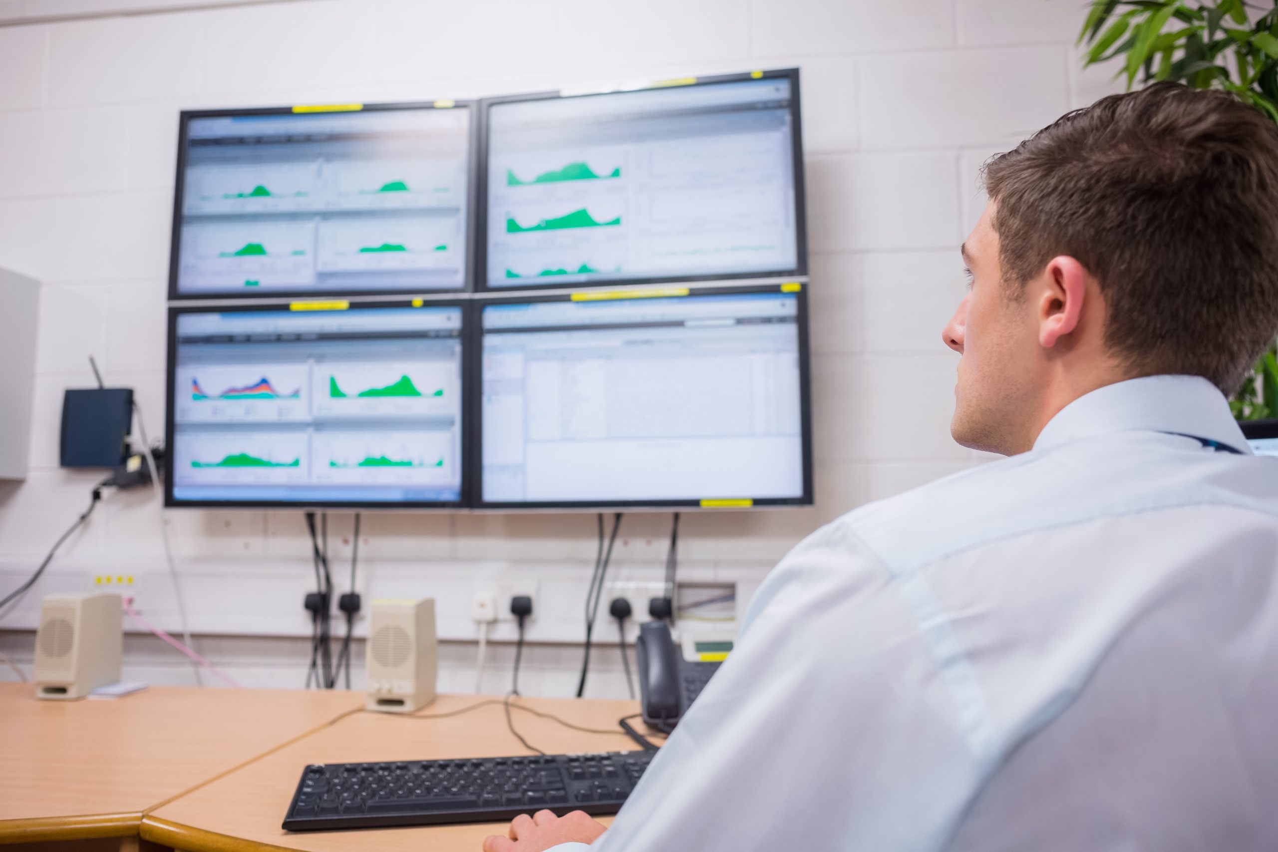 Seriöser Techniker, der im Büro auf einen Computerbildschirm schaut und eine Diagnose in einem großen Datenzentrum durchführt