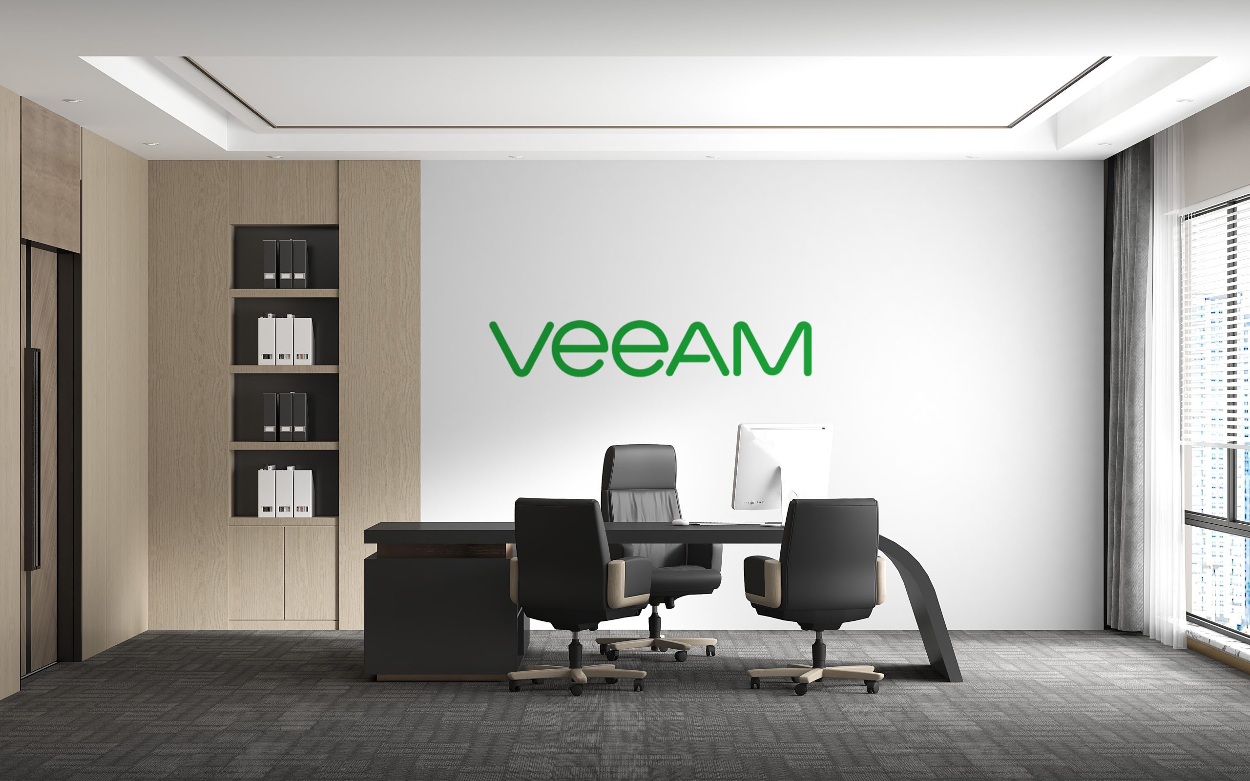 Aufgeräumtes Chefbüro mit IMac. An der Wand ist das Veeam Logo
