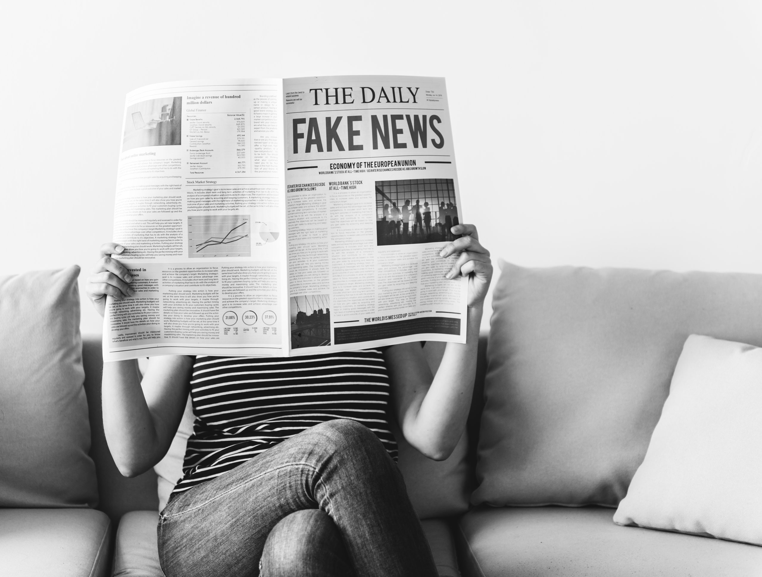 Eine Frau liest Zeitung auf der "Fake News" steht