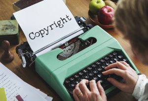 Person tippt auf schreibmaschine das Wort Copyright
