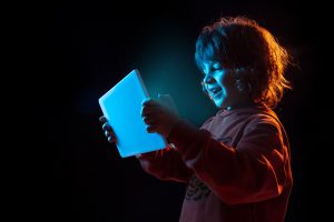 kleines Kind schaut in einen leuchtenden Bildschírm