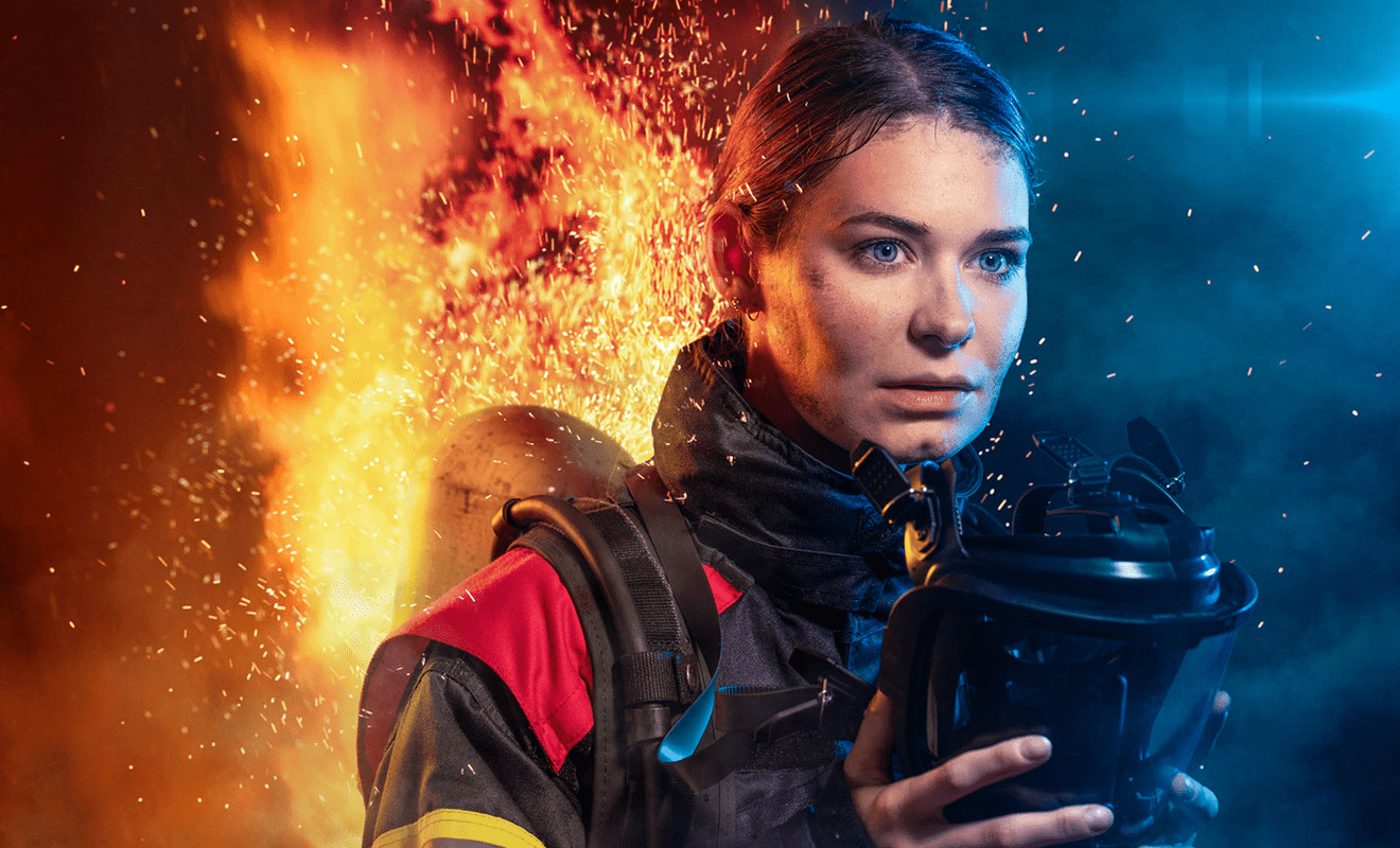 Junge Feuerwehrfrau steht in Flammen
